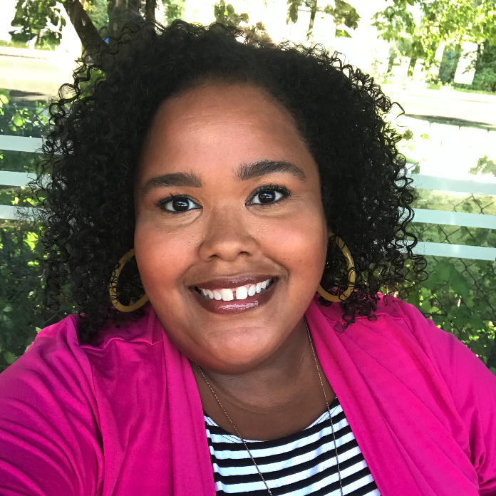 Photo of Zuly Inirio smiling outside in a pink blazer
