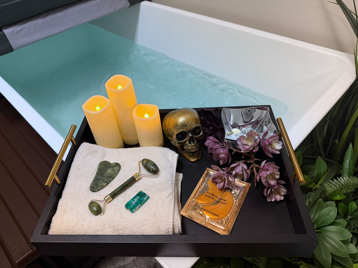 image of a welcome tray with candles, eye mask, skull decoration, and a cold plunge tub in the background